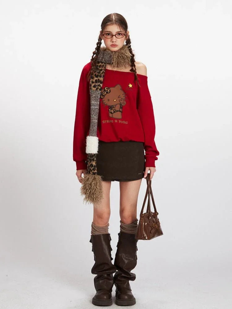 Woman wearing a red off-the-shoulder sweatshirt with a Hello Kitty graphic, brown mini skirt, brown knee-high boots, and a leopard print scarf.