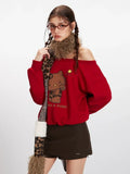 Close-up of a woman wearing a red off-the-shoulder sweatshirt with a Hello Kitty graphic, brown mini skirt, and a leopard print scarf.