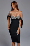 Close-up of the bodice of a black midi dress featuring pearl straps and sparkling embellishments.