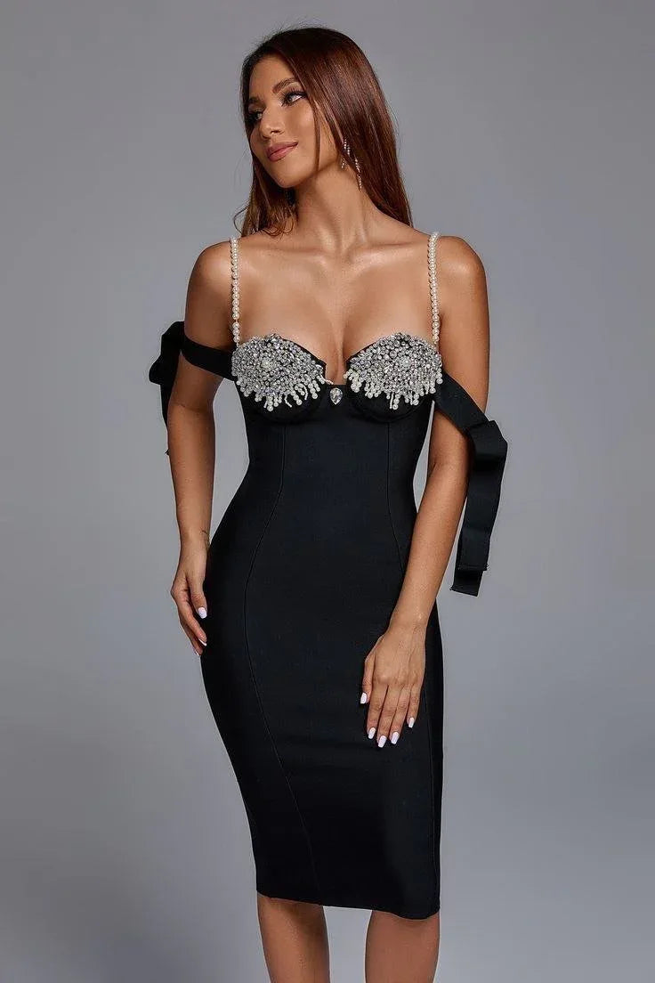 Close-up of the bodice of a black midi dress featuring pearl straps and sparkling embellishments.