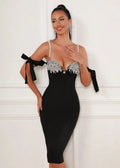 Model posing in a black bandage midi dress with a sweetheart neckline and detachable bow sleeves.